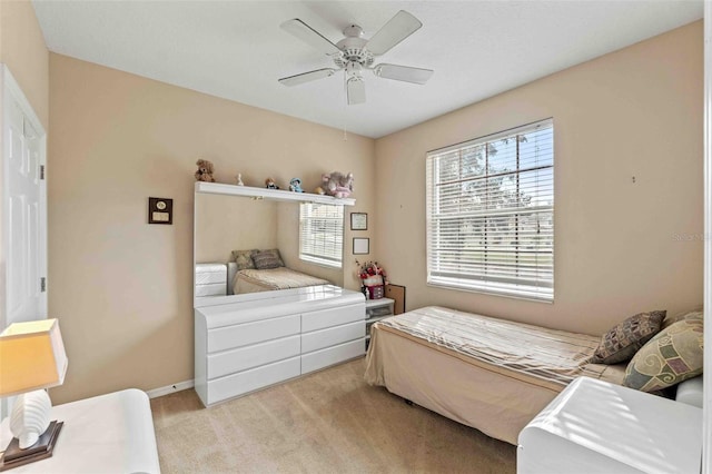 bedroom with ceiling fan and light carpet