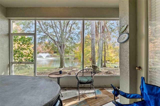 sunroom featuring a healthy amount of sunlight and a water view