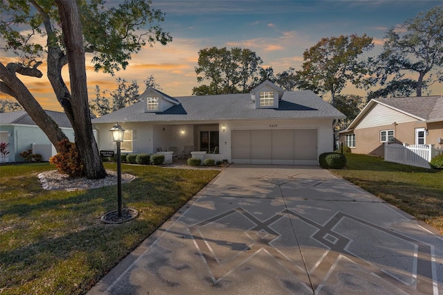 view of front of house featuring a garage and a lawn