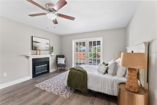 bedroom featuring ceiling fan, wood-type flooring, a textured ceiling, and french doors