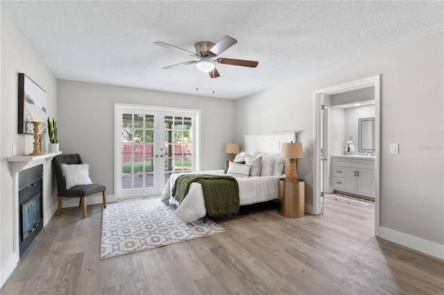 bedroom featuring access to exterior, ceiling fan, light hardwood / wood-style floors, and a textured ceiling