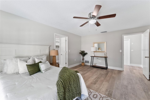 bedroom featuring a textured ceiling, light hardwood / wood-style floors, and ceiling fan