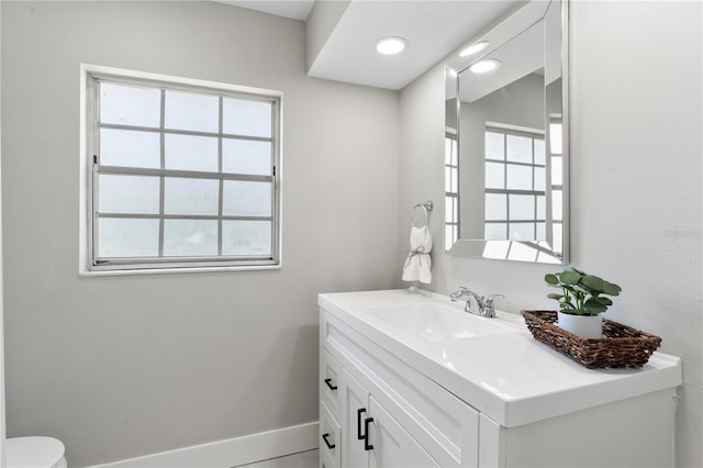 bathroom with tile patterned floors, vanity, and a healthy amount of sunlight