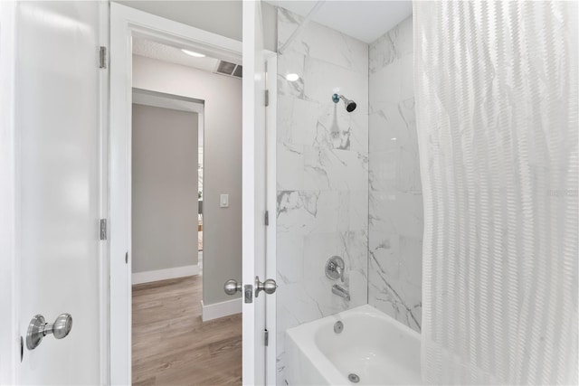 bathroom featuring shower / tub combo and hardwood / wood-style flooring