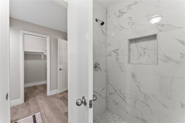 bathroom featuring a tile shower and hardwood / wood-style floors