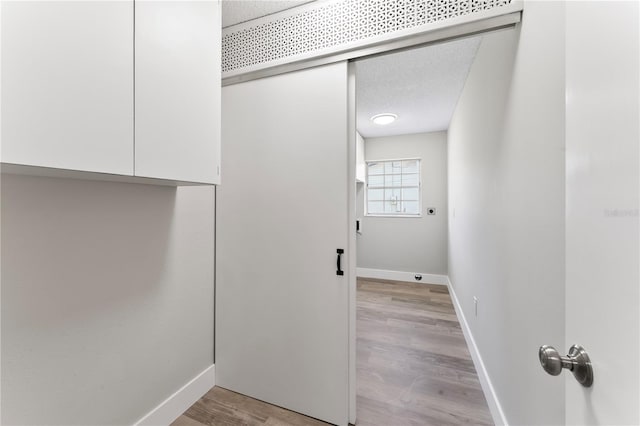 interior space featuring light hardwood / wood-style flooring, cabinets, and a textured ceiling