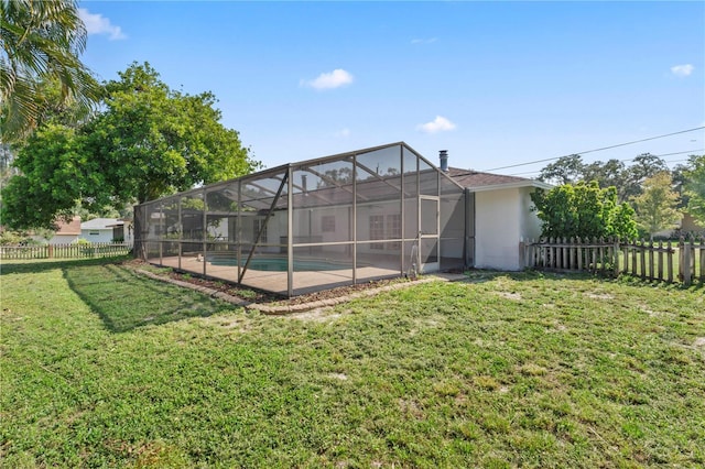 rear view of house featuring a lawn, a lanai, and a fenced in pool