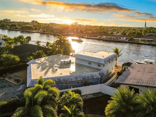 aerial view at dusk featuring a water view