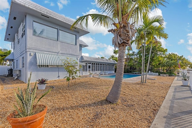 back of property featuring a fenced in pool