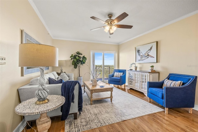 sitting room featuring ceiling fan, wood-type flooring, and ornamental molding