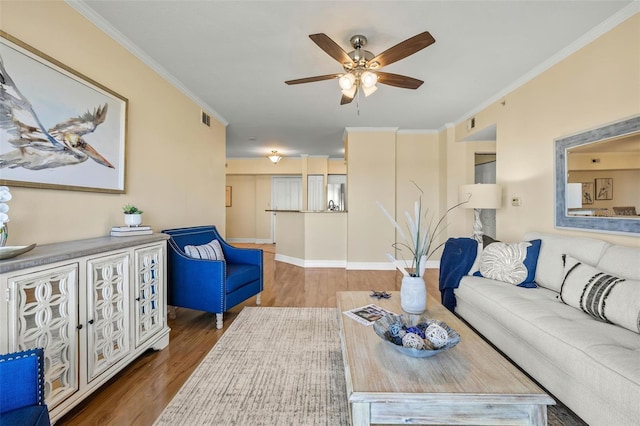 living room featuring hardwood / wood-style floors, ceiling fan, and ornamental molding