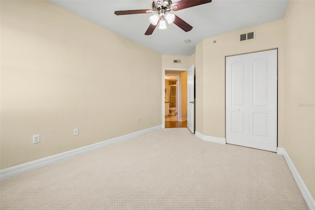 unfurnished bedroom with ceiling fan, a closet, and light carpet