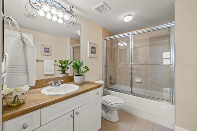 full bathroom featuring tile patterned flooring, vanity, a textured ceiling, and combined bath / shower with glass door