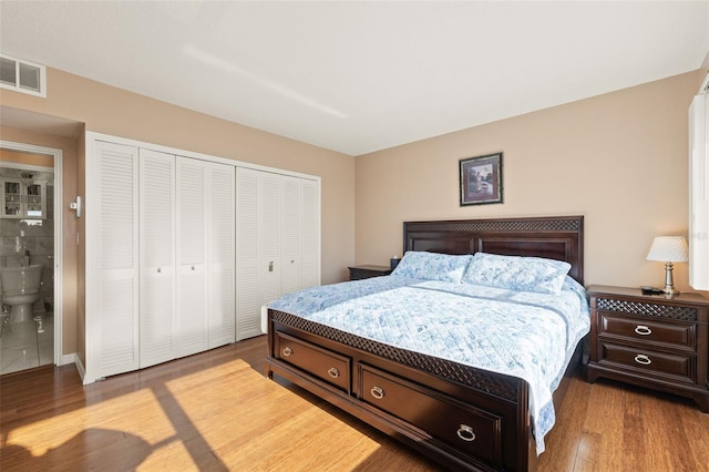 bedroom featuring ensuite bathroom, light hardwood / wood-style floors, and a closet