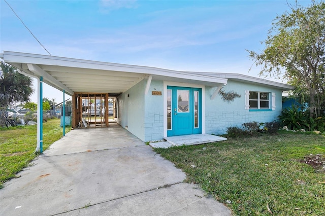 view of front of home with a front lawn and a carport