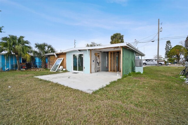 rear view of house with a lawn and a patio area