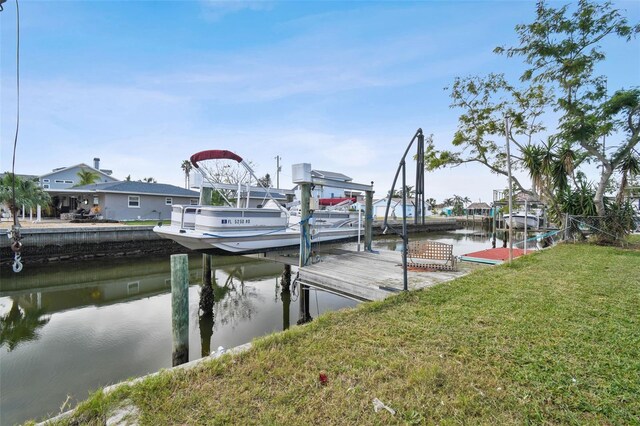 dock area featuring a water view and a lawn