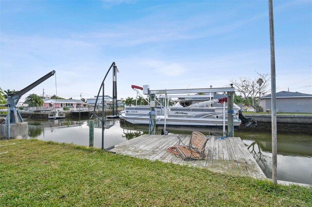 view of dock with a yard and a water view