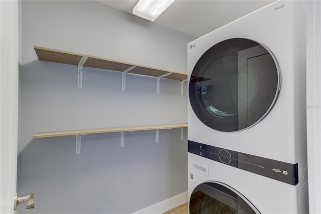 clothes washing area with stacked washer / dryer