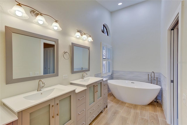 bathroom with vanity, a tub to relax in, and tile walls