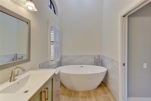 bathroom featuring vanity, a tub to relax in, and tile walls