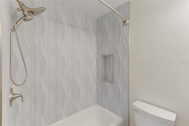 bathroom featuring toilet and tiled shower / bath