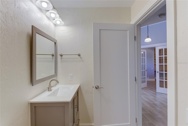 bathroom featuring french doors, vanity, and hardwood / wood-style flooring