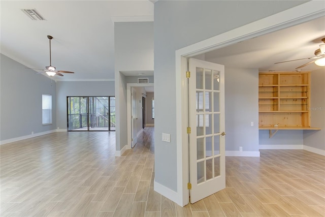 spare room with ceiling fan, light wood-type flooring, and crown molding