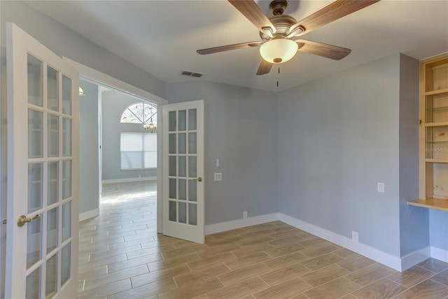 empty room featuring french doors, light hardwood / wood-style flooring, and ceiling fan