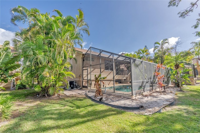 view of swimming pool featuring a lawn, a lanai, and a patio