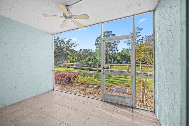 unfurnished sunroom featuring ceiling fan