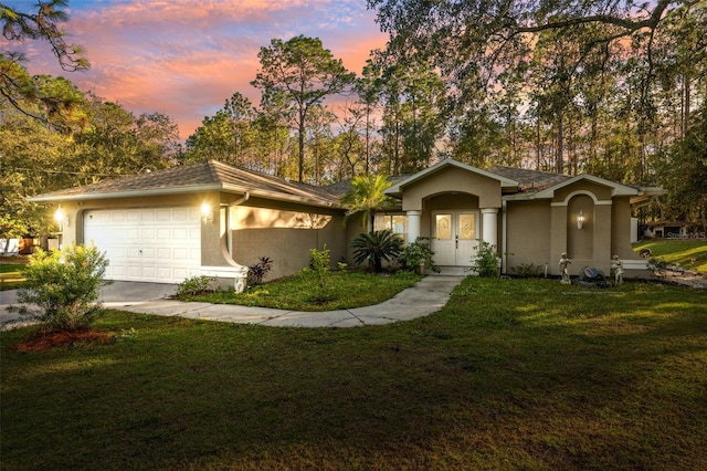 ranch-style house featuring a garage and a yard