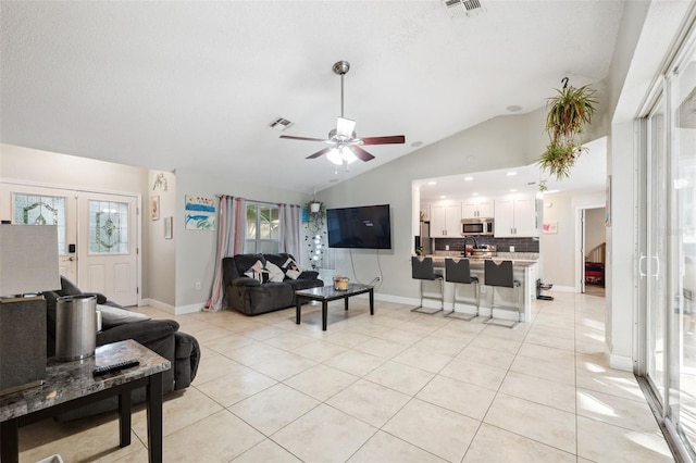 living room with light tile patterned floors, french doors, vaulted ceiling, and ceiling fan