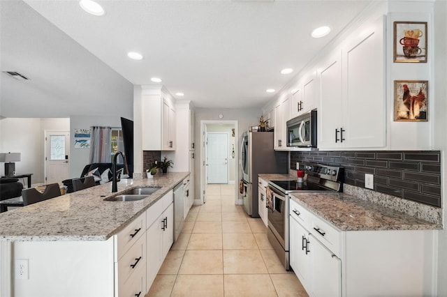 kitchen featuring white cabinets, sink, light stone countertops, kitchen peninsula, and stainless steel appliances