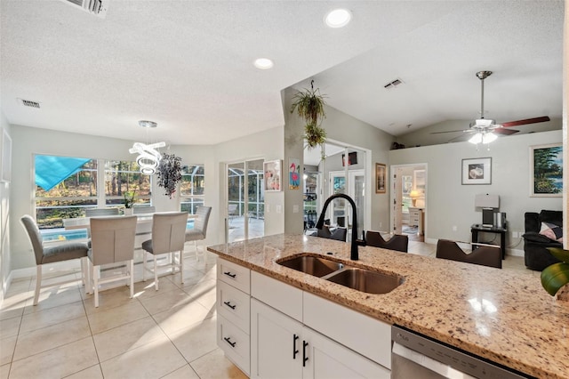 kitchen featuring dishwasher, white cabinetry, light stone counters, and sink