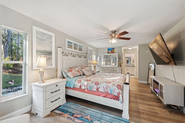 bedroom featuring ceiling fan, wood-type flooring, and a textured ceiling