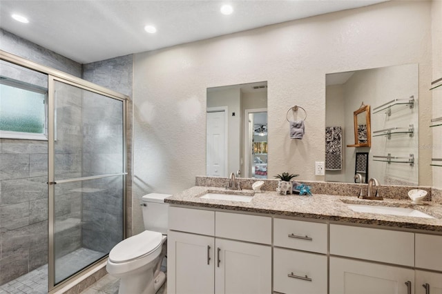 bathroom with a shower with door, vanity, plenty of natural light, and toilet