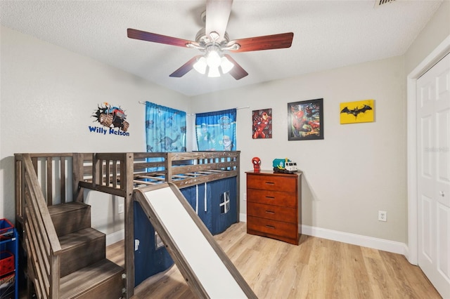 bedroom with ceiling fan, a textured ceiling, and hardwood / wood-style flooring