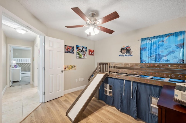 bedroom featuring wood-type flooring, a textured ceiling, and ceiling fan