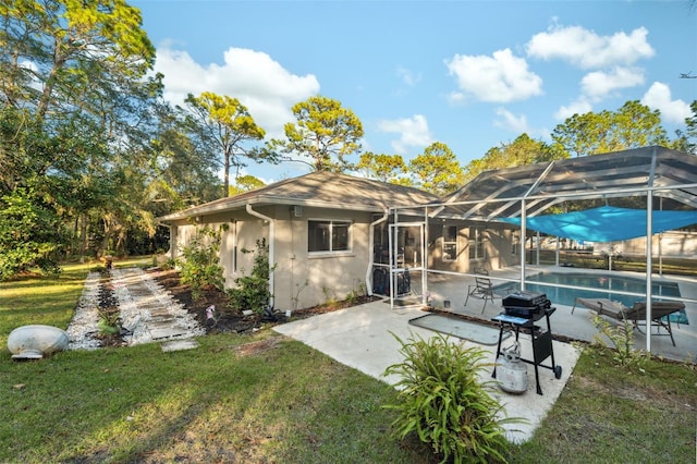 back of property featuring glass enclosure, a patio area, and a yard