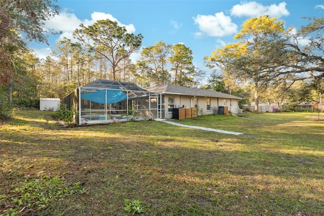 view of yard featuring a lanai and central air condition unit