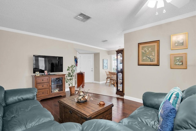 living room featuring dark hardwood / wood-style floors, ceiling fan, crown molding, and a textured ceiling