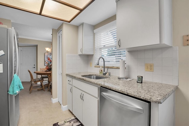 kitchen with crown molding, sink, tasteful backsplash, white cabinetry, and stainless steel appliances