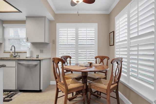 dining space with light tile patterned floors, ceiling fan, crown molding, and sink