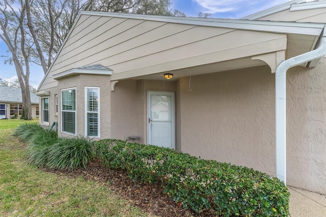 doorway to property featuring stucco siding