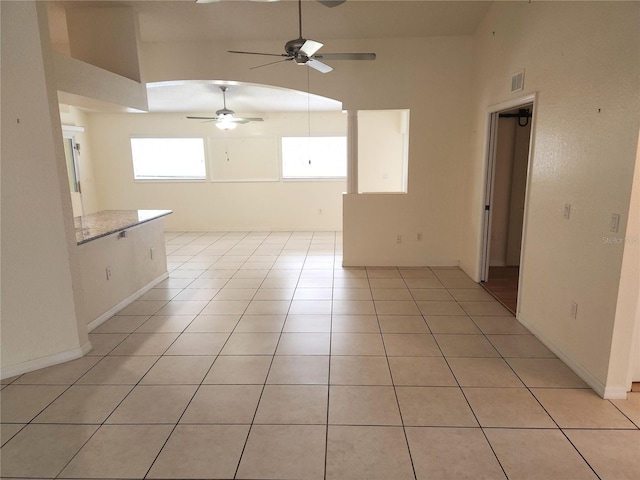 unfurnished room featuring high vaulted ceiling, ceiling fan, and light tile patterned flooring