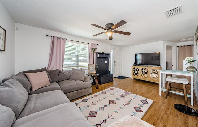 living area featuring light wood-type flooring, visible vents, and a ceiling fan