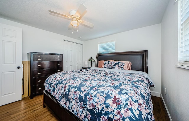 bedroom featuring wood finished floors, baseboards, ceiling fan, a closet, and a textured ceiling