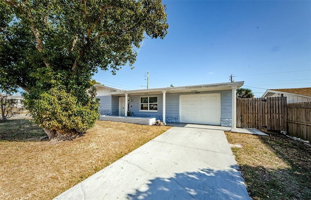 ranch-style house with concrete driveway, an attached garage, and fence