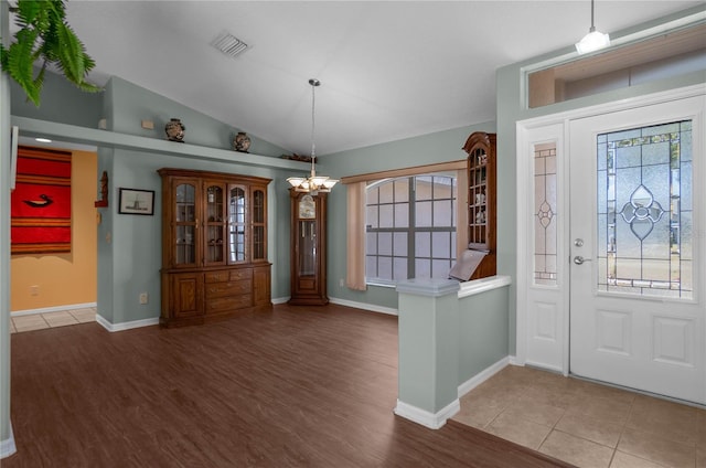 entryway featuring hardwood / wood-style floors, an inviting chandelier, and vaulted ceiling